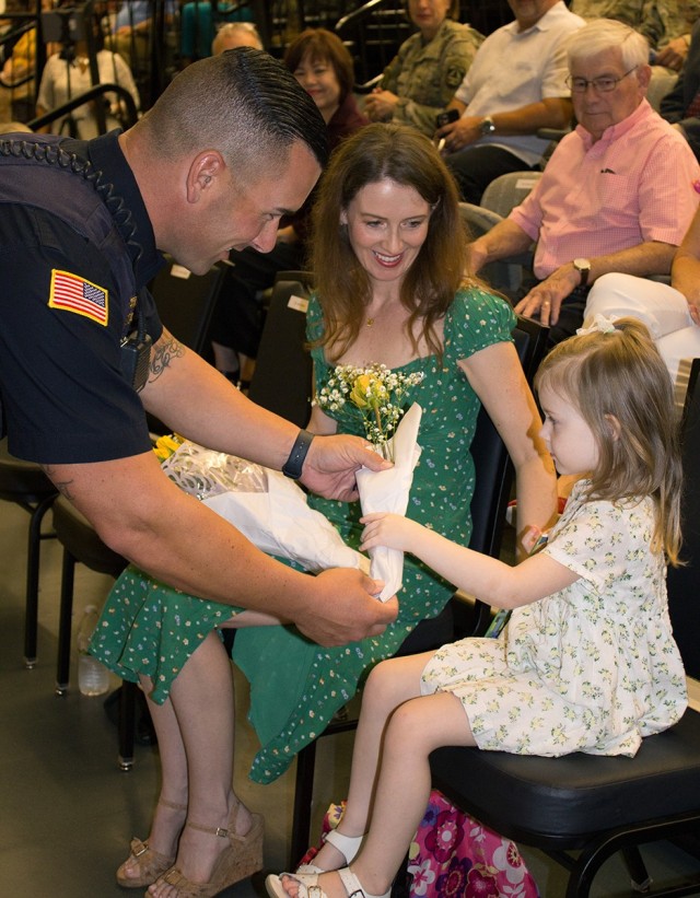 Col. Ned Marsh&#39;s wife and daughter receive yellow roses, in accordance with tradition, during Fort Detrick&#39;s garrison change of command ceremony, Aug. 18, 2022. Marsh is the new garrison commander.