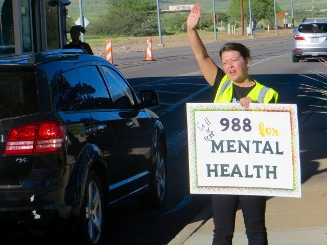                     Installation Suicide Prevention Program Manager Joanne Prince joins members of the U.S. Army Garrison Fort Huachuca team at the Buffalo Soldier Gate in greeting morning commuters Sept. 1, 2022, with messages of positivity and safety prior to the Labor Day long holiday weekend.           