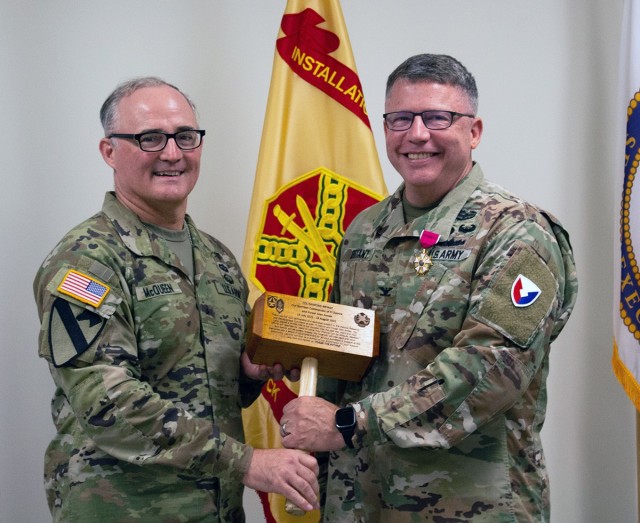 Brig. Gen. Anthony McQueen (left), commander of U.S. Army Medical  Research and Development Command and the senior leader on Fort Detrick, sends off Col. Danford Bryant with a gift recognizing his time as Fort Detrick’s garrison commander. 