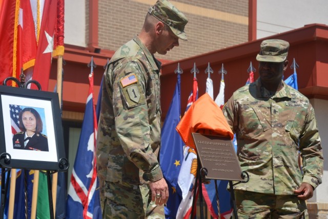 Command Sgt. Maj. Richard Meadows, former 21st Signal Brigade command sergeant major, left, and Command Sgt. Maj. Brent Smith, former Fort Gordon garrison command sergeant major, unveil a plaque memorializing Spc. Hilda Clayton during a barracks dedication on Fort Gordon on May 27, 2019. 
