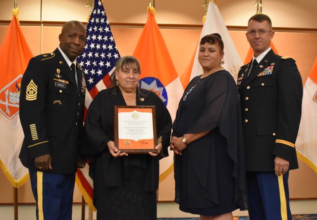 Spc. Hilda Clayton&#39;s mother, Evelyn Suarez (second from left), and Josie Suarez, Clayton&#39;s sister, are recognized during the Distinguished Members of the Regiment induction ceremony on Aug. 19. Also pictured are Command Sgt. Maj. Darien Lawshea and Col. Paul Howard, U.S. Army Signal School. 