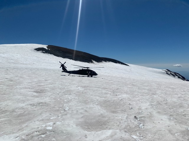 A UH-60L Black Hawk helicopter assigned to U.S. Army Air Ambulance Detachment-Yakima Training Center, 2-158 Assault Helicopter Battalion, 16th Combat Aviation Brigade sits atop Mount Adams, Wash. on Aug. 31, 2022. The aeromedical evacuation crew was deploying two civilian search-and-rescue team members to assist in the search for a lost climber. (Courtesy photo by Central Washington Mountain Rescue)