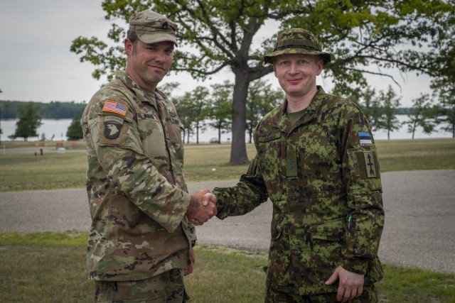 First Lt. Sven Pärand, right, a company commander in the Estonian Defense League, shakes hands with U.S. Army Staff Sgt. Joel Parham, scout squad leader from the 3-126th Infantry Regiment, at Camp Grayling, Michigan, July 19-23, 2022, while participating in the Military Reserve Exchange Program. (U.S. Air National Guard photo by Staff Sgt. Jacob Cessna)
