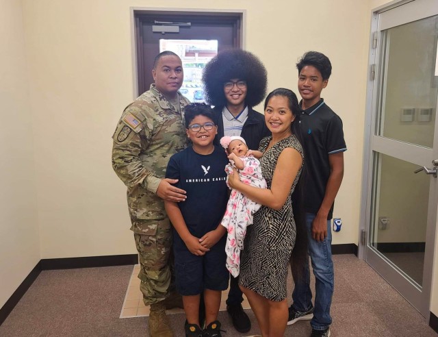 Chief Warrant Officer 2 Keith Joell, who is assigned to U.S. Army Japan, poses for a photo with his family inside the Camp Zama recruiting office in Japan, July 20, 2022. In the background are Ke’Shaun and Geovanni, and in the foreground are Julius, Angelina Sky, and Joell&#39;s wife, Windy. Joell administered the oath of enlistment to Ke’Shaun at the same installation where he enlisted into the Army when Ke’Shaun was a newborn baby.