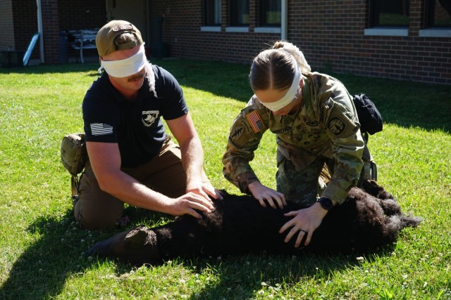 A Soldier learns how to medically treat an injured military working dog during a simulation exercise at the Muscatatuck Urban Training Center in Butlerville, Ind.