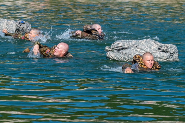 Combat engineer and bridge crewman trainees with Company B, 35th Engineer Battalion, cross the lake at Training Area 250 Wednesday with poncho rafts as an add-on to the field-training exercise portion of their instruction. Building poncho rafts is...