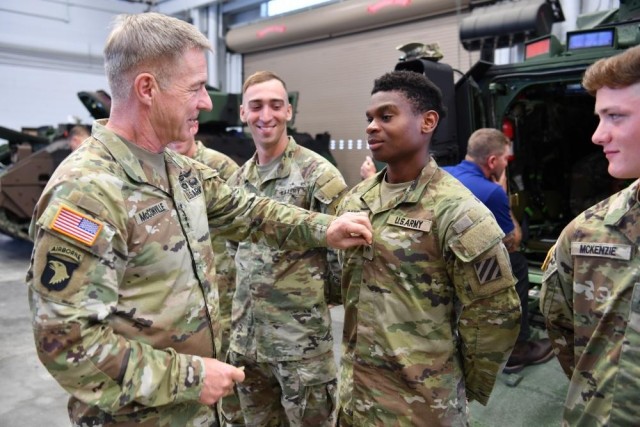 Chief of Staff of the Army Gen. James C. McConville, left, promotes Pvt. Samuel Rand, right, an M2A4 Bradley Fighting Vehicle gunner assigned to the 9th Brigade Engineer Battalion, 2nd Armored Brigade Combat Team, 3rd Infantry Division, to the rank of private first class during his visit to Fort Stewart, Georgia, on March 23, 2022. 