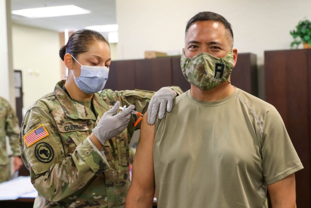 First  Army physician assistant, Maj. Kelly Ann Guerra administers an influenza vaccine to Lt. Gen. Antonio Aguto Jr., First Army commanding general.