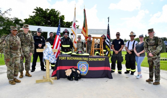 Fort Buchanan US Army Garrison Command Group, Police, Firefighters, Soldiers, Emergency Medical Service/First Responders, stand in honor and tribute behind the display in commemoration of 9/11. On the left is the wooden cross built by Fort...