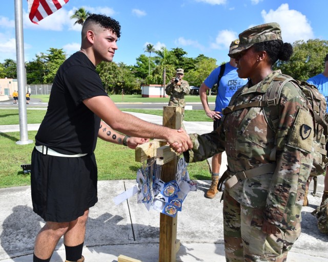 (R) Fort Buchanan US Army Garrison Commander Col. Tomika M. Seaberry thanked Service Members and Soldiers from the 166th RSG Brigade as they placed the “Fallen Heroes” placard they wore during the march in tribute to a fallen 9/11...