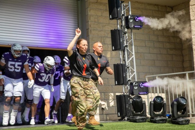 1st Infantry Division Deputy Commanding General-Support, U.S. Army Brig. Gen. Niave F. Knell, and 1st Infantry Division Command Sergeant Major-Riley, U.S. Army Command Sgt. Maj. Albert Serrano, run onto the field with the Kansas State University football team prior to kickoff, as part of Fort Riley Day at the Bill Snyder Family Stadium in Manhattan, Kansas on September 17, 2022. Kansas State University’s Fort Riley Day is an annual event that celebrates K-State’s connection to Fort Riley and also honors Soldiers serving at home and overseas. (U.S. Army photo by Pfc. Kenneth Barnet)