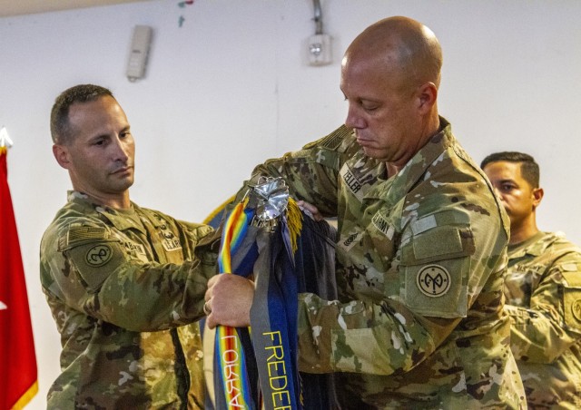 U.S. Army Lt. Col. Shawn Tabankin, the commander of 1st Battalion, 69th Infantry Regiment, and Command Sgt. Maj. Jason Zeller, the 1st Battalion, 69th Infantry Regiment, senior enlisted leader, unfurl the unit’s colors during a transfer-of-authority ceremony at Camp Lemonnier, Djibouti, Sep. 19, 2022. More than 1,100 New York Army National Guard Soldiers officially began their service as part of Combined Joint Task Force – Horn of Africa. (U.S. Army photo by Staff Sgt. Alexander Rector)