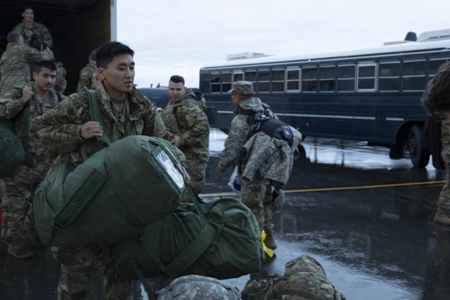 Soldiers of the Alaska Army National Guard transfer their luggage prior to boarding a HC-130 Combat King II for transport to Bethel, Alaska, Sept. 21, 2022. Approximately 100 members of the Alaska Organized Militia, which is comprised of the Alaska National Guard, Alaska State Defense Force and Alaska Naval Militia, were activated following a disaster declaration issued Sept. 17 after the remnants of Typhoon Merbok caused dramatic flooding across more than 1,000 miles of Alaskan coastline.