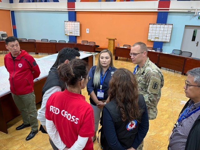 US Army soldier Maj. Kmiecik, 8th Forward Resuscitative Surgical
Detachment, speaking with Mongolian WHO (World Health Organization) and Red Cross/Red Crescent members of the National EOC simulation. (Courtesy photo by U.S. Army Soldier)
