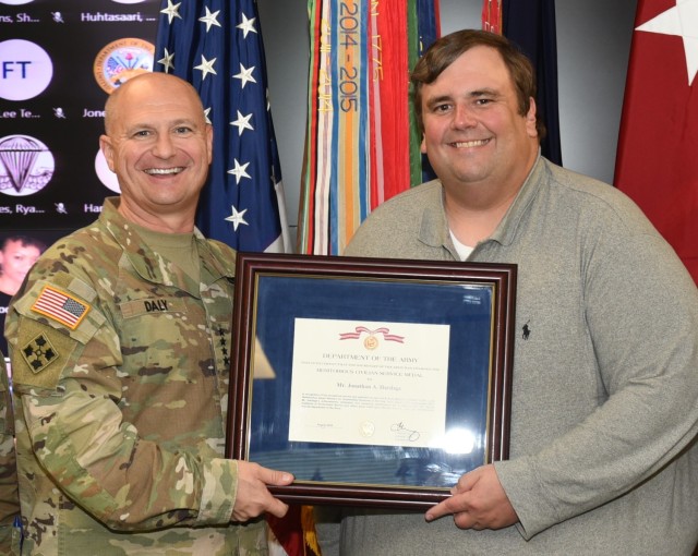 Gen. Ed Daly, Army Materiel Command commanding general, presents the Dellamonica Award to Jonathan Hardage, AMC contract attorney, during a recognition ceremony Sept. 22 at AMC headquarters. Hardage was one of 11 command recipients recognized with the award given to AMC’s outstanding personnel of the year for 2021. 