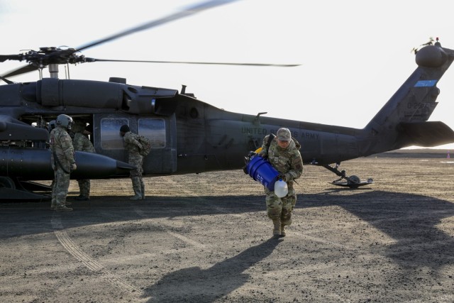 Alaska Air National Guard Staff Sgt. Kua Xiong, a services technician with the 176th Force Support Squadron, arrives in Toksook Bay, Alaska, via a UH-60L Black Hawk helicopter assigned to A Company, 1st Battalion, 168th Aviation Regiment, to help...