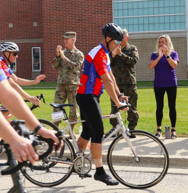 Maj. Gen. Rich Neely, the adjutant general of Illinois and commander of the Illinois National Guard; Polish Gen. Cezary Wisniewski, deputy commander of the Polish Armed Forces, and Neely's spouse, Tammy, cheer on Gold Star 500 bicycle riders...