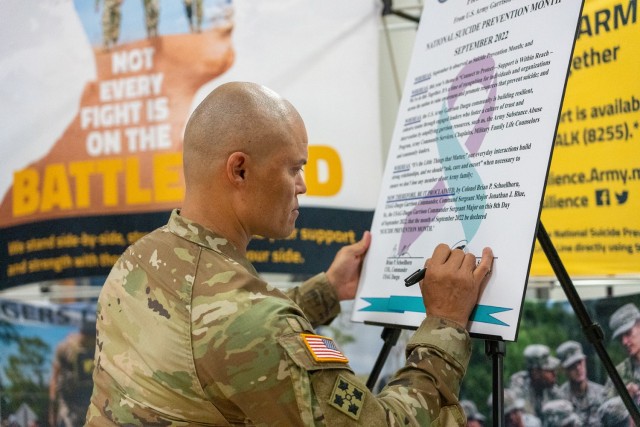 U.S. Army Garrison Daegu Senior Enlisted Leader Command Sgt. Maj. Jonathon J. Blue signs a pledge to intervene when others need help during a Resiliency Day event at Camp Walker, Republic of Korea, September 8, 2022. The Army Substance Abuse Program team organized the event to educate the community about resources available to help people navigate adversity and reach out to others experiencing suicidal ideations.