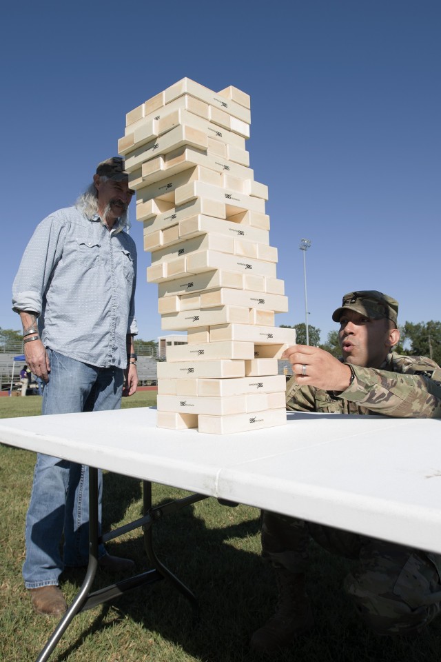 Kyle Nordmeyer (left) and Sgt. 1st Class Brian Wimer, from the Fort Leonard Wood Office of the Inspector General, participate in a tumbling tower game with wood blocks during a suicide prevention awareness and education event Tuesday on Gerlach...