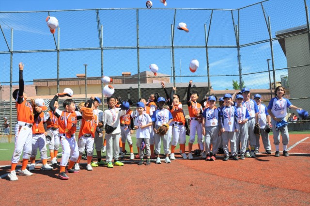 Daegu CYS and Korean youth baseball players celebrate the end of the tournament at Kelly Field on Camp Walker, Republic of Korea. The tournament is part of a cultural exchange experience organized by the Daegu CYS staff.  