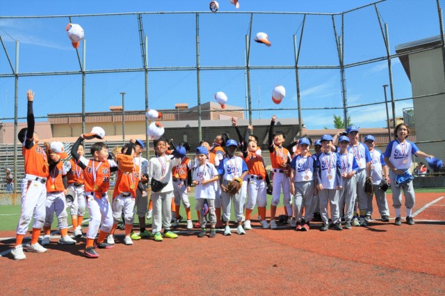 Daegu CYS and Korean youth baseball players celebrate the end of the tournament at Kelly Field on Camp Walker, Republic of Korea. The tournament is part of a cultural exchange experience organized by the Daegu CYS staff.