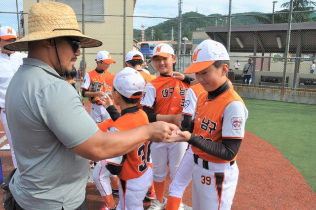 A member of the U.S. Army Garrison Daegu CYS staff presents metals to players on a Korean team playing in a tournament at Camp Walker, Republic of Korea. The tournament is part of a cultural exchange experience organized by the Daegu CYS staff.  