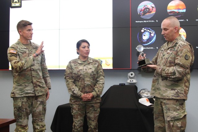 NETCOM Deputy Commander for Operations Col. Scott Bird prepares to present the 2022 Regional Cyber Center of the Year trophy to RCC-P Director Lt. Col Michael T. Denison and Sergeant Major Claudia Twiss. The event was held at the NETCOM command headquarters, Fort Huachuca, Arizona, September 20, 2022. 