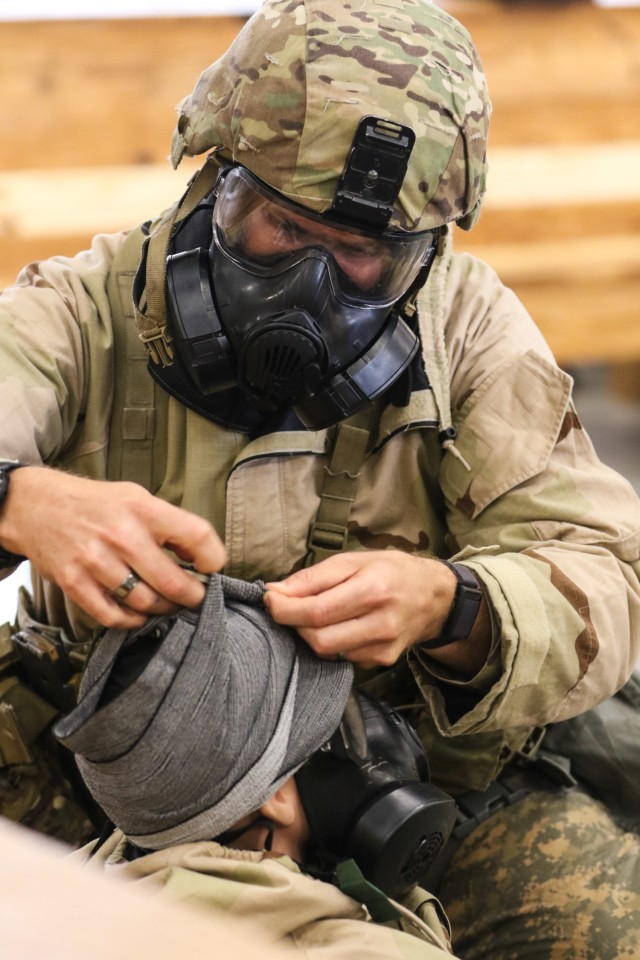 A U.S. Soldier competing in the Army’s first-ever Best Squad Competition tests his medical proficiency while wearing MOPP (Mission Oriented Protective Posture) Gear during medical testing lanes at Fort Bragg, North Carolina, on September 30, 2022. The Army Best Squad Competition tests Soldiers on their individual and collective ability to adapt to and overcome challenging scenarios and battle-readiness events that test their physical endurance, technical skills, and tactical abilities under stress and extreme fatigue.