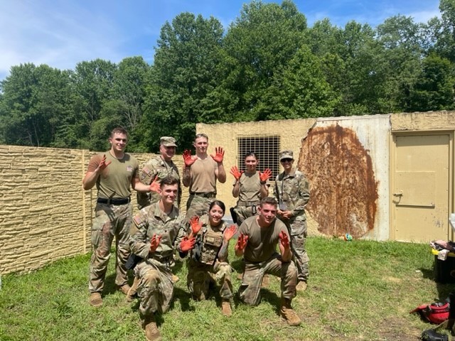 Handlers take a class picture with Maj. Gen. Miller and Sgt. Maj. Viridiana Lavalle, Military Working Dog Program Manager, Office of the Provost Marshal General, after conducting combat medical scenario-based training.