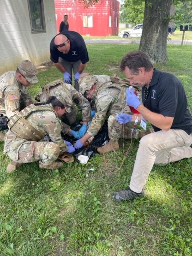 Instructors from Veterinary Tactical Group observe handlers as they conduct Canine Tactical Combat Casualty Care (TC3) training.