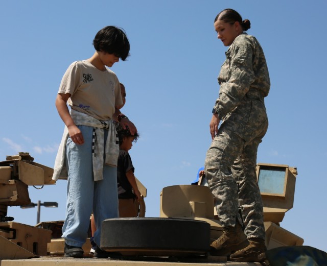 Spc. Taylor Rogers from 3rd Armored Brigade Combat Team, 1st Armored Division, walks a fair visitor through the specs of an M1 Abrams tank at the El Paso Police Department Community Fair at Joey Barraza and Vino Memorial Park, Sept. 10. The event was an opportunity for Fort Bliss Soldiers to connect with the local El Paso community, and showcase various types of combat equipment used by the Army.