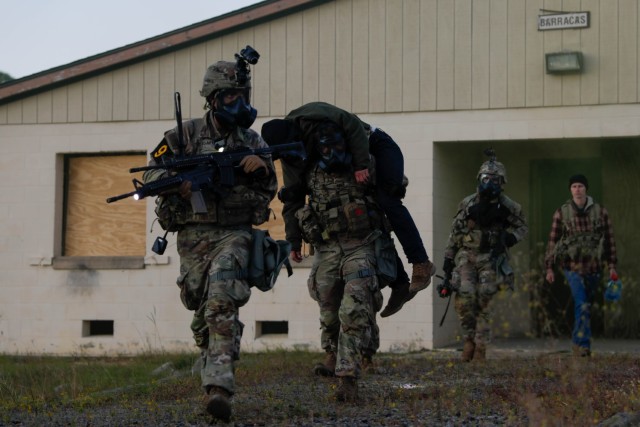 U.S. Army Spc. Conner Crisafi (left), Sgt. Garret Paulson, (center), Spc. Paulo Dasilva (right) and Soldiers of Squad 9, representing the U.S. Army Medical Command work together to escort a casualty during the first ever best squad competition on Fort Bragg, North Carolina, Oct 4, 2022. Each squad competing in the Army Best Squad Competition consists of five soldiers; a squad leader, which is a sergeant first class or staff sergeant; a team leader, which is a sergeant or corporal; and three squad members in the ranks of specialist or below.