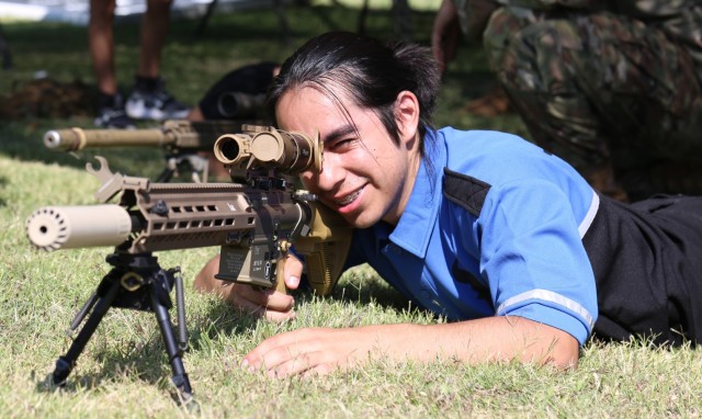 A high school student practices a good shooting position with a sniper weapon at the El Paso Police Department Community Fair at Joey Barraza and Vino Memorial Park, Sept. 10. The event was an opportunity for Fort Bliss Soldiers to connect with the local El Paso community, and showcase various types of combat equipment used by the Army.
