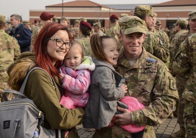 A proud family congratulates a paratrooper who has just been awarded his Expert Infantryman Badge, as she is held at a ceremony at the 173rd Airborne Brigade.