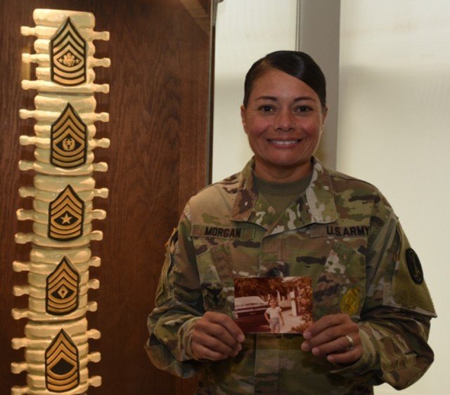 Sgt Maj. Mariel Morgan, a career counselor assigned to the U.S. Army Military District of Washington located at Fort Lesley J. McNair in Washington, D.C., holds a picture of her when she was younger. Morgan was born in Caguas, Puerto Rico. 