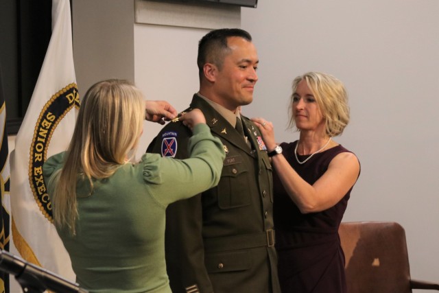 Lt. Col. Michael Flint&#39;s new rank is pinned on by wife Lisa and daughter Ashleigh in a promotion ceremony held at DEVCOM AvMC headquarters, Oct. 6.