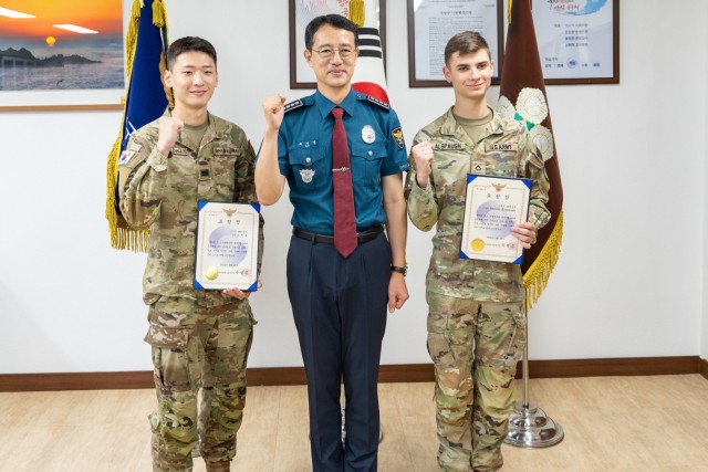 Cpl. Oh Jae Yoon and Pfc. Dalton Alspaugh pose for a photo with Nam-bu Police Chief Bae Ki-myong after receiving certificates of appreciation at Nam-bu Police Station in Daegu, Republic of Korea, October 4, 2022. On September 13, 2022, Oh and Alspaugh provided emergency support assistance to a traffic accident victim  until Korean first responders could arrive. 
