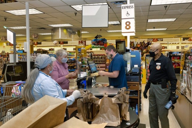 Precila Jackson, left, William Dwyer, behind the register and Sam Somerville, Commissary store director, assist customers during the 2021 Commissary’s sidewalk sale held in honor of retirees during Retiree Appreciation Day. 