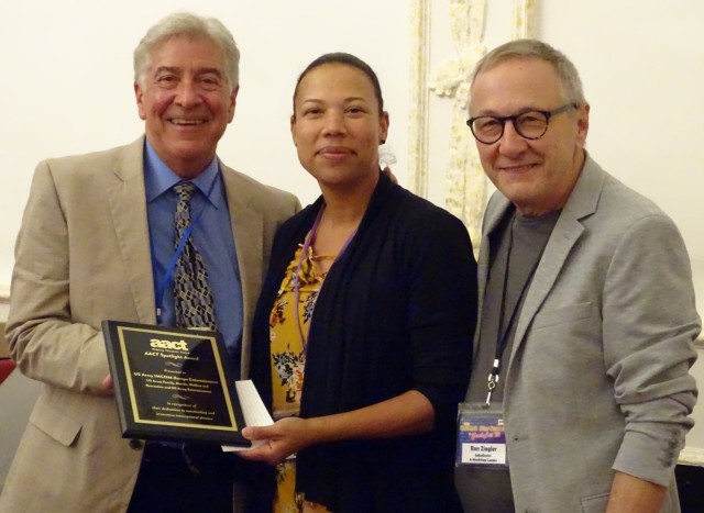 Dane Winters, IMCOM Entertainment program manager accepts the American Association of Community Theatre Spotlight Award from Quiana Clark-Roland, AACT executive director. Also pictured is Ron Ziegler, international
adjudicator. 

“This honor is in recognition of not only the staff’s support of their communities,” Clark-Roland said, “but also for their dedication to outstanding and innovative international theater.”
