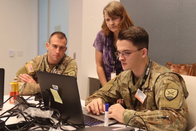 Virginia National Guard Soldiers assigned to the 91st Cyber Brigade work with civilian cyber specialists during the Cyber Fortress exercise Sept. 27, 2022, in Richmond, Virginia. NOTE: Photo digitally altered for security reasons. (U.S. National Guard photo by Cotton Puryear)