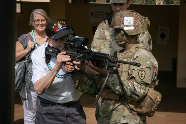 Private 2nd Class (ret.) Warren H. Schuster holds a M249 Light Machine Gun during a visit to 2nd Battalion, 35th Infantry Regiment, 3rd Infantry Brigade Combat Team, 25th Infantry Division, on Schofield Barracks, Hawaii, Oct. 21, 2022. Accompanied by his three daughters, 91-year-old Schuster visited the 25th Inf. Div. and his prior unit more than seven decades after fighting and subsequently being injured in the Korean War. (U.S. Army photo by Sgt. Rachel Christensen/28th Public Affairs Detachment)