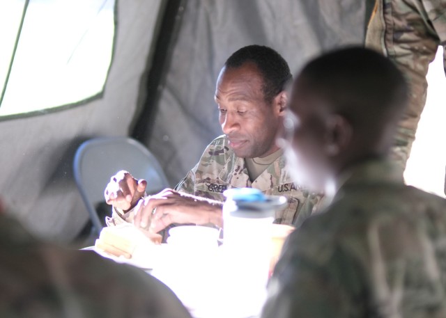 Sgt. First Class Marcel Green, a Transportation Movement Supervisor assigned to the 688th Rapid Port Opening Element, eats dinner in the field during a training exercise at Fort Eustis, Va. Oct 6.