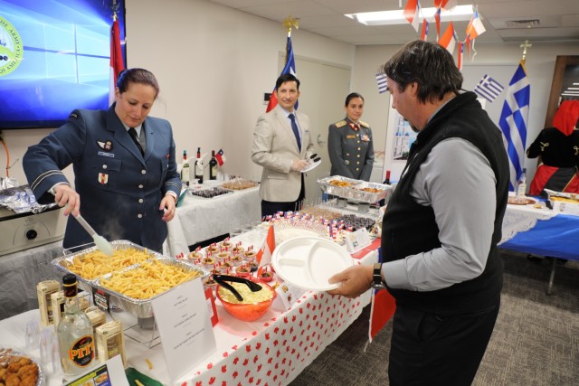 U.S. Army Security Assistance Command&#39;s Michael Casciaro, G4 Director and Senior Representative at USASAC&#39;s New Cumberland, Pennsylvania headquarters, visits Canadian SALO Captain Melissa Bryan’s station during the 2022 International Buffet. The International Buffet was held Oct. 20, 2022 and is a celebration paying respect to the 13 home countries of USASAC SALO officers. SALOs like Bryan streamline logistics and monitor Foreign Military Sales cases for their militaries. 