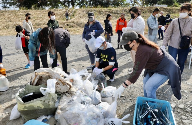 Freiwillige häufen Müll auf, den sie am 30. Oktober 2022 während einer Säuberungsaktion außerhalb der Gemeinde auf dem Shindo-Sportplatz der Stadt Sagamihara in der Nähe von Camp Zama, Japan, gesammelt haben.  Ungefähr 40 Freiwillige aus Camp Zama schlossen sich den Freiwilligen der Stadt Sagamihara, der Stadt Zama und der Japan Ground Self-Defense Force für die gemeinsame Säuberung an.