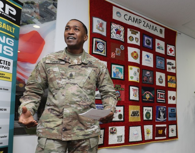 Command Sgt. Maj. Justin E. Turner, senior enlisted leader of U.S. Army Garrison Japan, speaks during a ceremony to unveil a community quilt at Camp Zama, Japan, Nov. 1, 2022. The first-ever community quilt was designed by more than 35 units and private organizations.