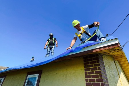 Members of the Army Corps of Engineers install blue, protective sheeting on homes affected by Hurricane Ian in Fort Myers, Fla., Oct. 8, 2022.