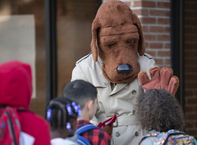 McGruff the Crime Dog hands out red ribbons to students as they enter C.C. Pinckney Elementary School Oct. 24 as part of Red Ribbon Week.