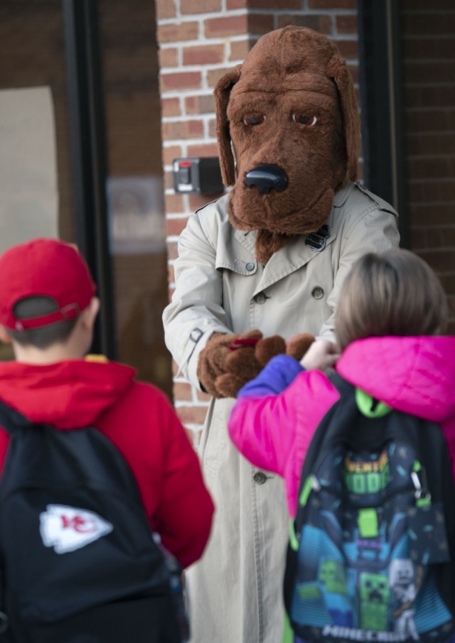 McGruff the Crime Dog hands out red ribbons to students as they enter C.C. Pinckney Elementary School Oct. 24 as part of Red Ribbon Week.