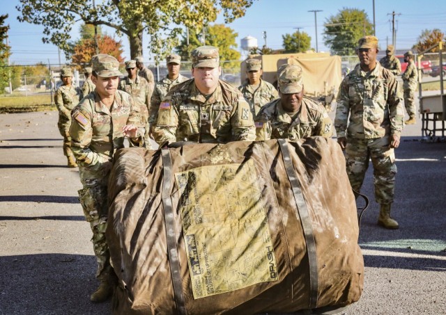 Soldiers work as a team opening tent.