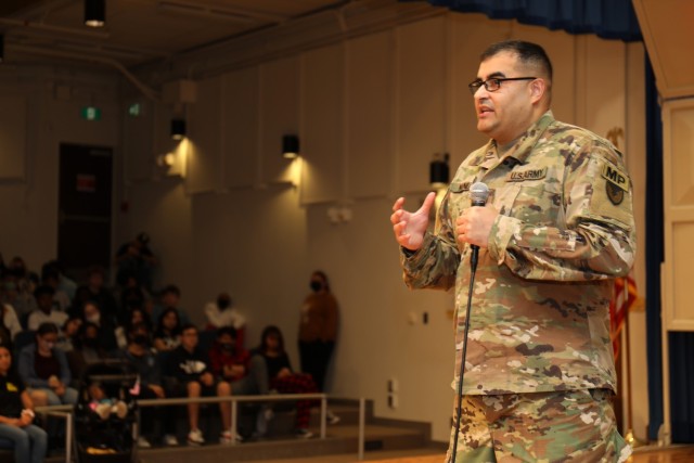 Staff Sgt. Benigno Nunez, assigned to the 88th Military Police Battalion, shares his personal experiences of witnessing the deadly consequences of drugs and excessive alcohol use with students during a Red Ribbon Week assembly inside the Zama Middle High School auditorium at Camp Zama, Japan, Nov. 3, 2022.